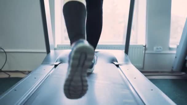 Vrouw draait op loopband in de sportschool — Stockvideo