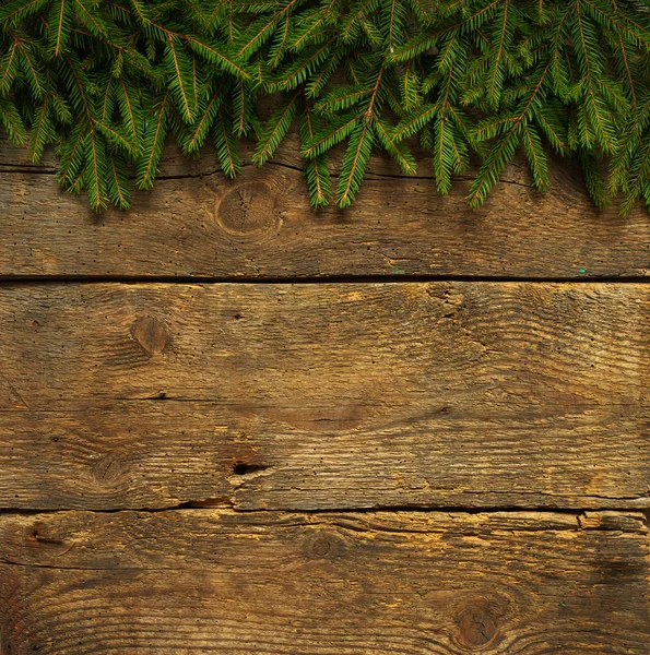 Weihnachtsbaumzweige auf hölzerner Textur — Stockfoto