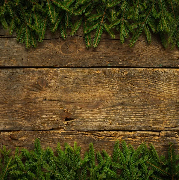 Ramas de árbol de Navidad en textura de madera — Foto de Stock