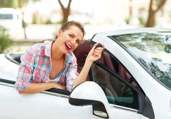 Mujer está de pie cerca del coche descapotable con las llaves en la mano — Foto de Stock