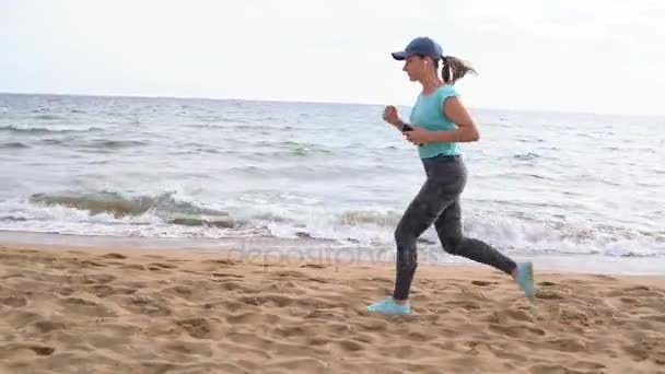 Sportieve vrouw loopt langs het strand — Stockvideo