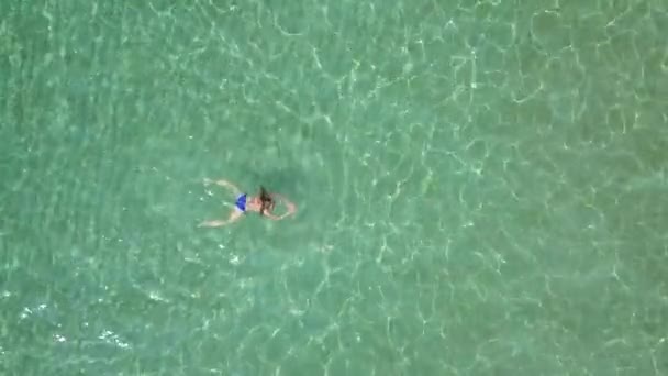 Blick aus der Höhe auf schwimmende Frau im klaren Meer — Stockvideo