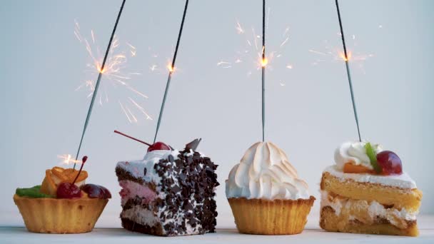 Cupcakes diferentes com sparklers. Ideia para feriados, aniversários, aniversários, celebrações e festas — Vídeo de Stock