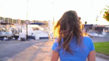 Gün batımında, yat ve tekne bir sürü rıhtım boyunca yürüyüş güneş gözlüklü kadın yakın çekim