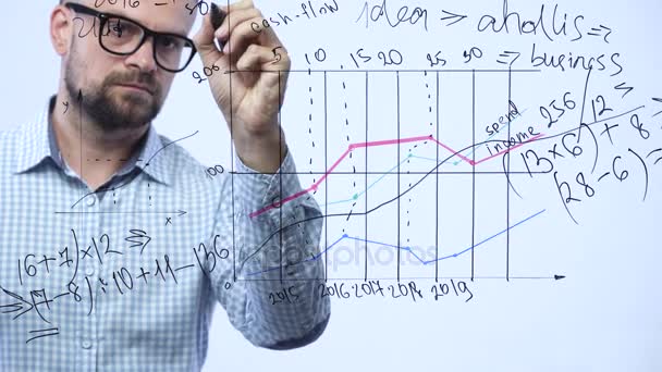 El hombre dibuja varias tablas de crecimiento, calculando las perspectivas de éxito en una moderna oficina de vidrio — Vídeos de Stock