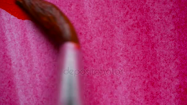 Dessin avec un pinceau sur papier blanc avec aquarelle rouge gros plan 