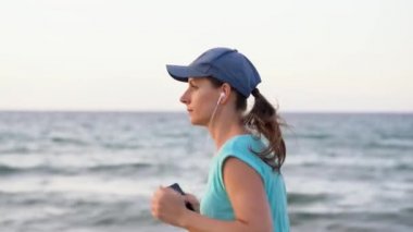Plaj boyunca çalıştıran atletik kadın. Video farklı hızlarda - hızlı, normal ve yavaş
