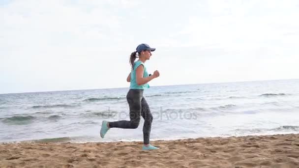 Donna atletica che corre lungo la spiaggia. Video a velocità diverse - veloce, normale e lento — Video Stock