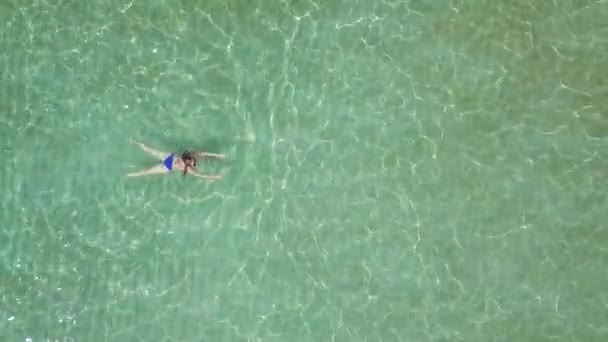 Blick aus der Höhe auf schwimmende Frau im klaren Meer — Stockvideo