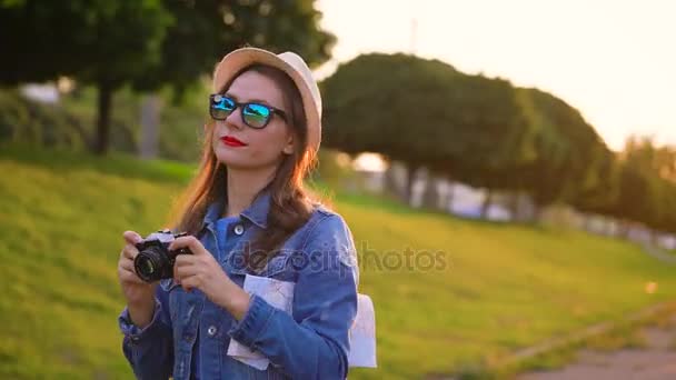 Girl is walking around the city and taking photos of nature and sights on a film camera — Stock Video