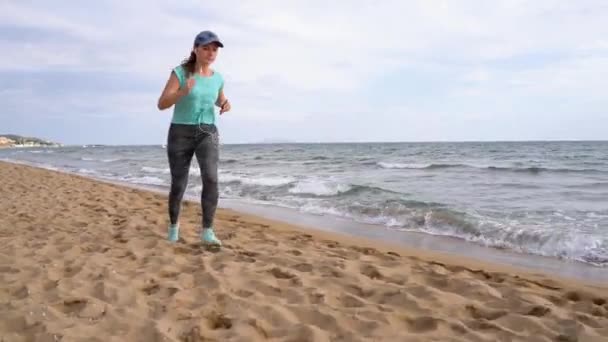 Mulher atlética correndo ao longo da praia — Vídeo de Stock