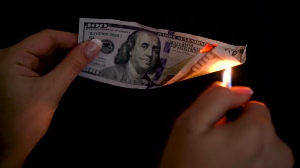 Burning dollars in a hand close-up on a black background. Slow motion — Stock Video