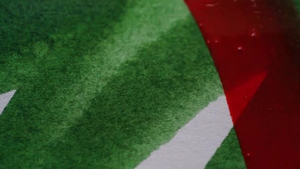 Vypracování s štětec na bílém papíře s červenými akvarel přes zelené zavřít — Stock video
