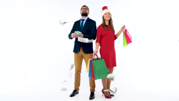 Dólares cayendo sobre hombres y mujeres formalmente vestidos con el sombrero de Santa Claus. Vamos a ir de compras navideñas y celebrar el concepto . — Vídeo de stock