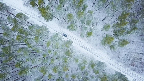 Aerial view on car driving through winter forest road. Scenic wi — Stock Photo, Image