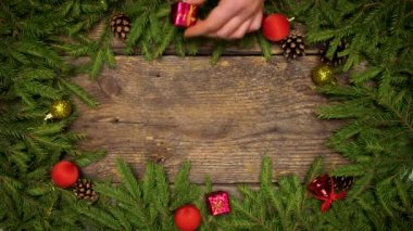 Bayan eller bir Noel dekor oluşturmak. Noel ağacı dalları ile koni ve Noel dekorasyonları ahşap doku tasarımlarınız için hazır