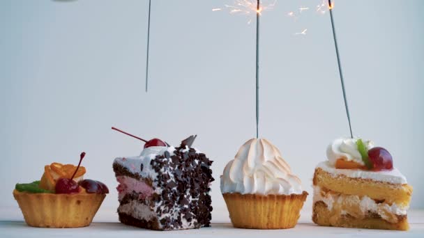 Diferentes cupcakes con bengalas. Idea para fiestas, cumpleaños, aniversarios, celebraciones y fiestas — Vídeos de Stock