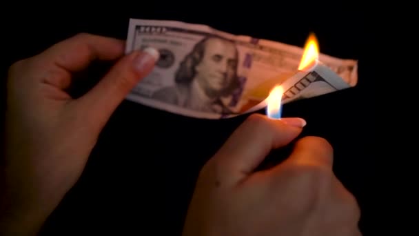 Brûler des dollars dans une main gros plan sur un fond noir — Video