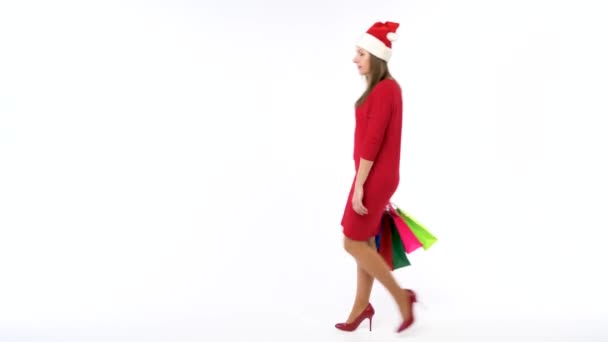 Christmas kvinnliga shopper håller mångfärgade shoppingkassar på vit bakgrund i studio. Lets go semester shopping koncept — Stockvideo