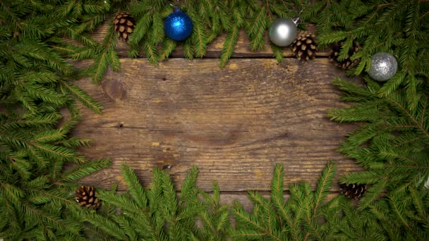 Womens handen maken een kerst decor. Kerstboom takken met kegels en kerstversiering op houten textuur klaar voor uw ontwerp — Stockvideo