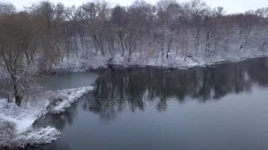 Uçuş orman ve nehir kıyısı boyunca sahilde kar ile kaplı