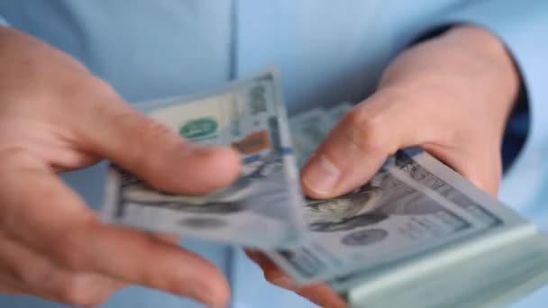 Close-up van mans handen tellen honderd dollarbiljetten — Stockvideo