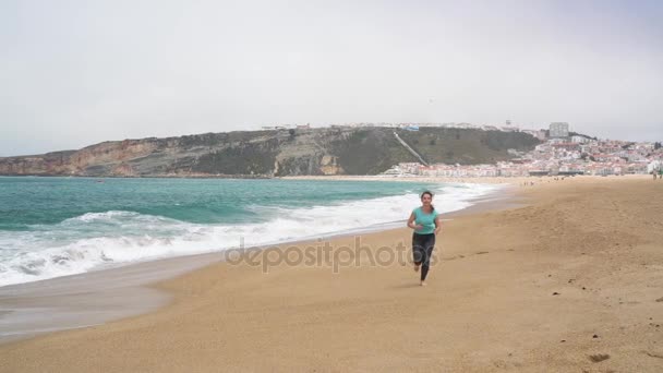 Athletische Frau, die am Strand entlang läuft. Zeitlupe — Stockvideo
