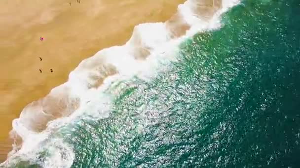 Vista superior sobre silhuetas de pessoas andando descalças ao longo da praia do oceano de areia molhada. Costa portuguesa do Oceano Atlântico — Vídeo de Stock