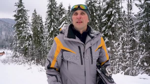 Man med skidor under armen stiger till berget förbereder för nedstigningen — Stockvideo