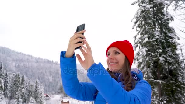 Mujer joven utiliza un teléfono inteligente para hacer una fotosde una hermosa vista en las montañas, Cárpatos — Vídeos de Stock