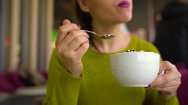 Bir kafede bir kaşık ile çırpılmış krema, çikolata şurubu ile kahve içme kadın