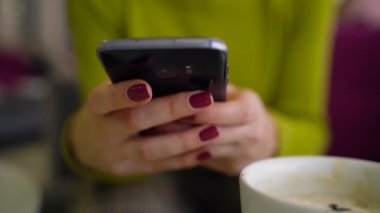 Smartphone kullanarak ve kafede kahve içme kadın yakın çekim