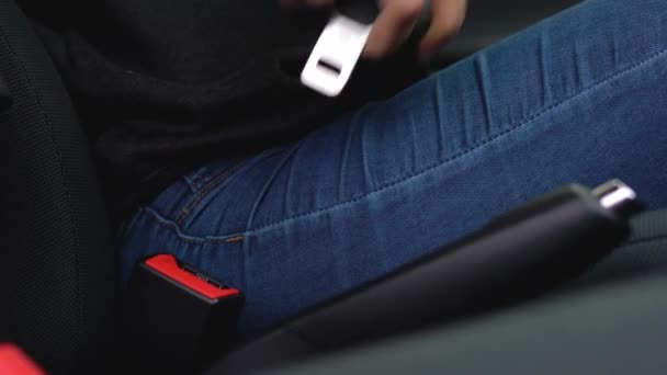 Female hand fastening car safety seat belt while sitting inside of vehicle before driving — Stock Video