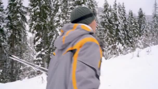 Homme avec des skis sous son bras se lève à la montagne se préparant pour la descente — Video