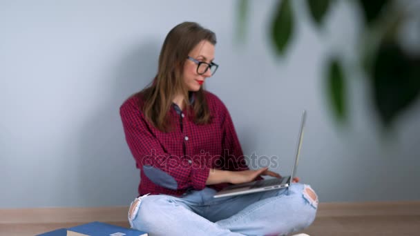 Menina bonita usando laptop sentado no chão em casa — Vídeo de Stock