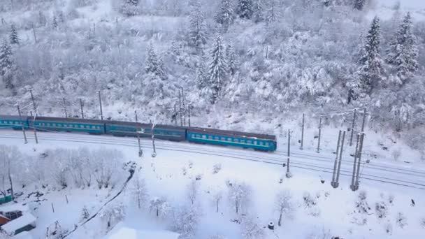 Aerial view of the train going through the mountainous terrain in winter — Stock Video