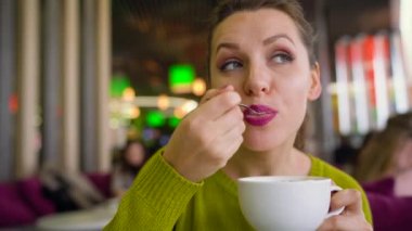 Bir kafede bir kaşık ile çırpılmış krema, çikolata şurubu ile kahve içme ve bir arkadaşıma söz kadın