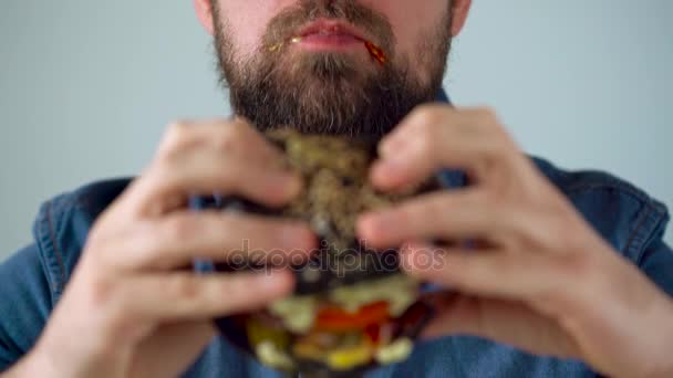 El hombre come hamburguesa jugosa — Vídeos de Stock