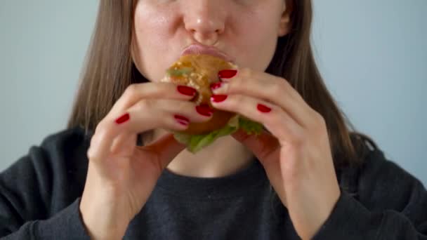 Женщина ест сочный гамбургер — стоковое видео