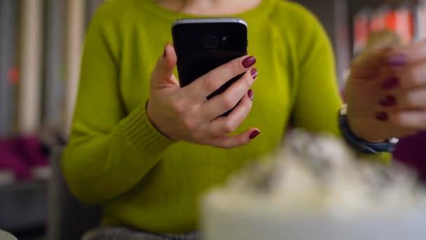 Woman using smartphone and drinking coffee in cafe close up — Stock Video