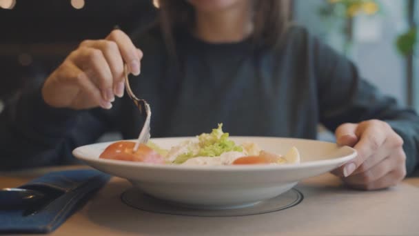 Женщина ест салат Цезарь в кафе — стоковое видео