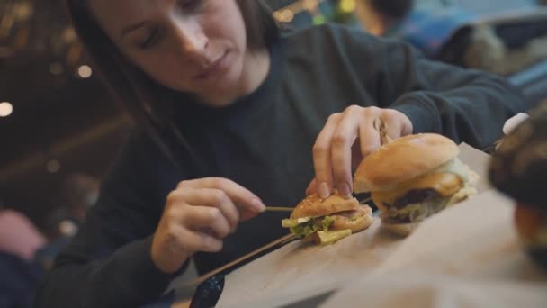 Femme mange un hamburger dans un café — Video