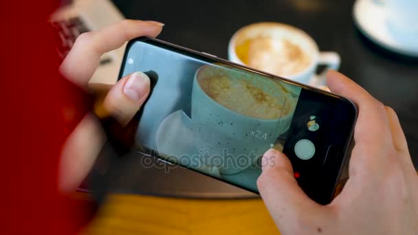 Chica hace una foto de café en un teléfono inteligente en un café de cerca — Vídeos de Stock