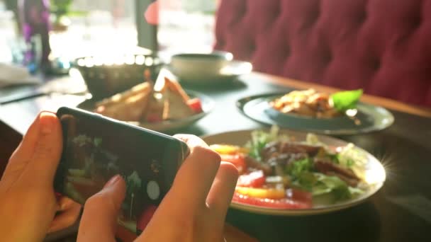 Gadis membuat foto makanan di smartphone di sebuah kafe dekat — Stok Video