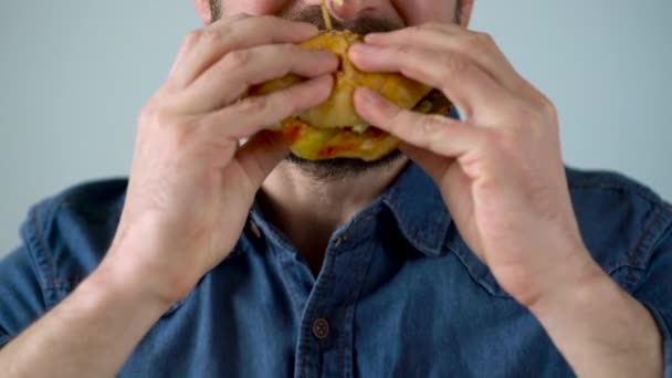 Man eats juicy hamburger — Stock Video