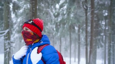 Yalnız turist kız kış karla kaplı iğne yapraklı bir ormanda dağlarda yürüyüş. Soğuk hava. Ağır çekim
