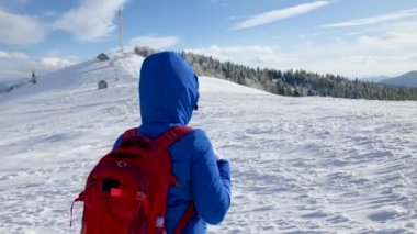 Yalnız turist kız bir dağın tepesine yürüyüş karla kaplı. Açık soğuk hava