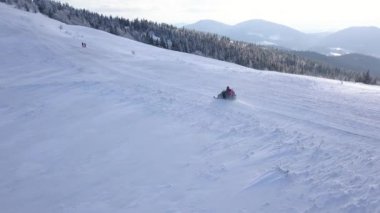 İnsanlar güzel karlı dağ yamacında snowmobile sürüş üzerinde yükseklikten görüntüleyin. Açık soğuk hava