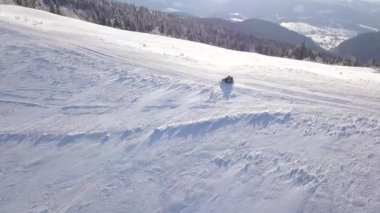 İnsanlar güzel karlı dağ yamacında snowmobile sürüş üzerinde yükseklikten görüntüleyin. Açık soğuk hava