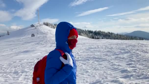 孤独的旅游女孩走在山顶上, 覆盖着积雪。晴朗的寒冷天气 — 图库视频影像